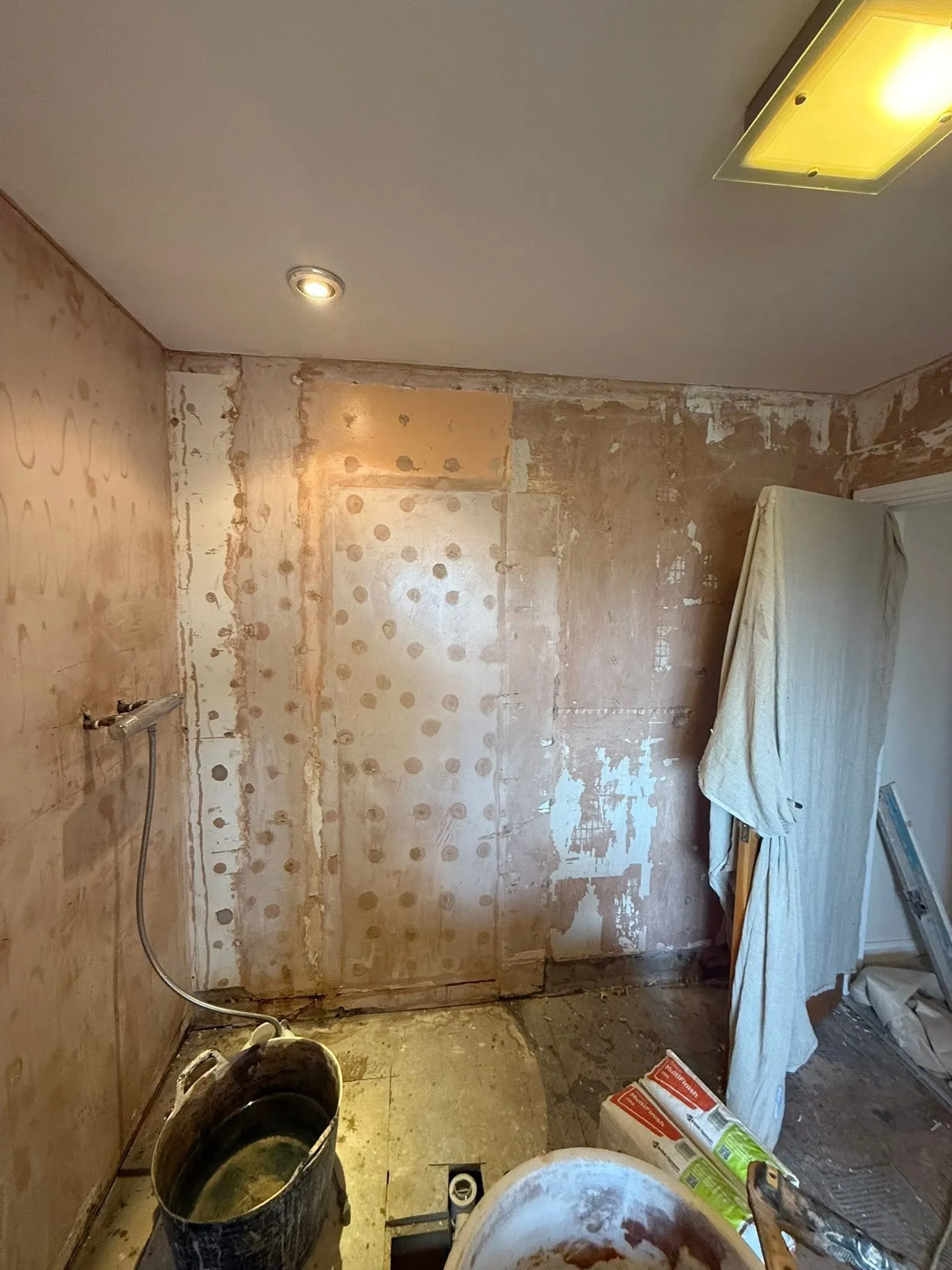 Freshly plastered walls in a bathroom mid-renovation
